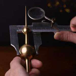 Precise measurements being taken on a handcrafted brass replica of the Kuwait Towers, ensuring accuracy and attention to detail. Turath